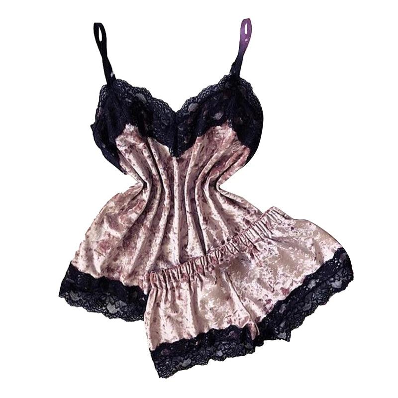 Traje de renda e veludo rosa com detalhes em preto. O traje inclui um top com alças e decote em V, bem como um short com laço