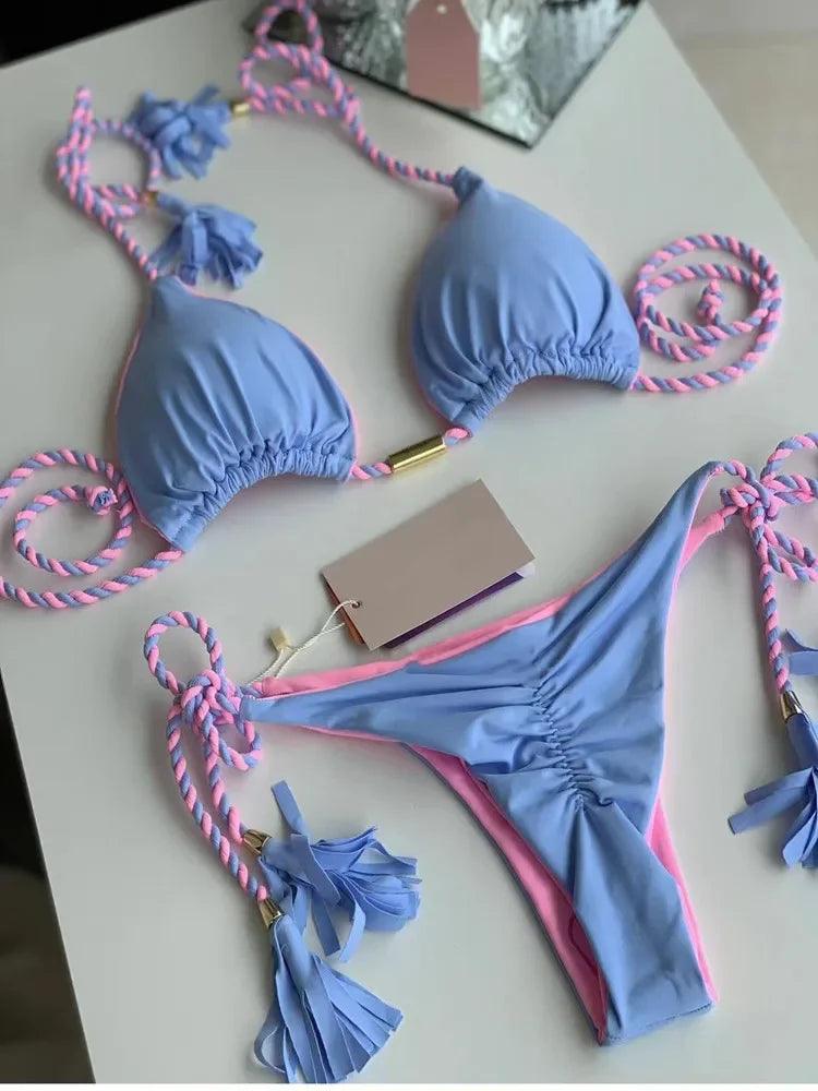 Bikini azul e rosa com cordas decorativas e etiqueta de preço.