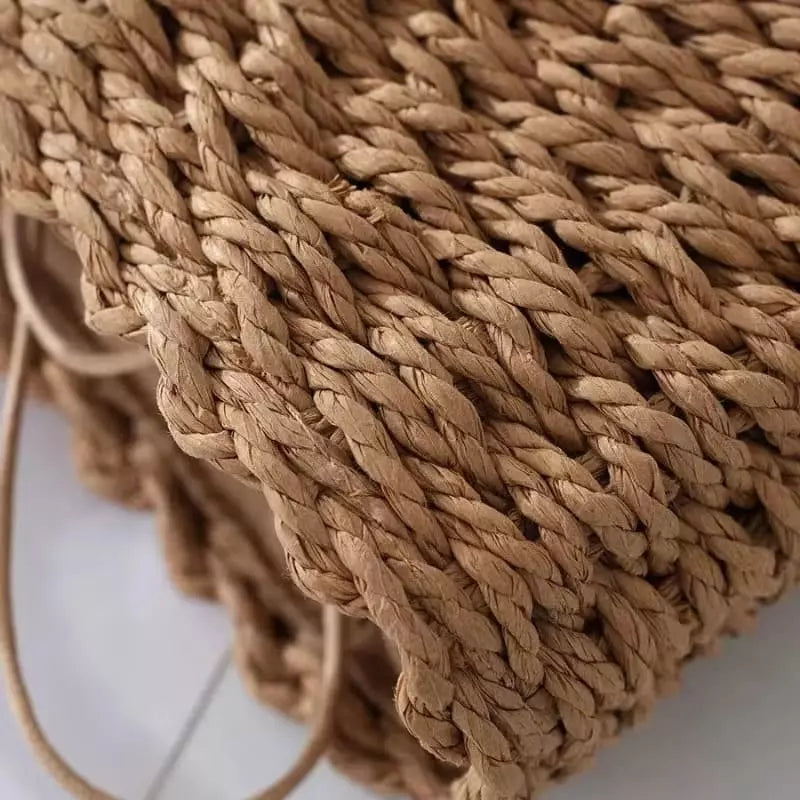 Close-up da textura trançada em fibra natural de bolsa artesanal de palha