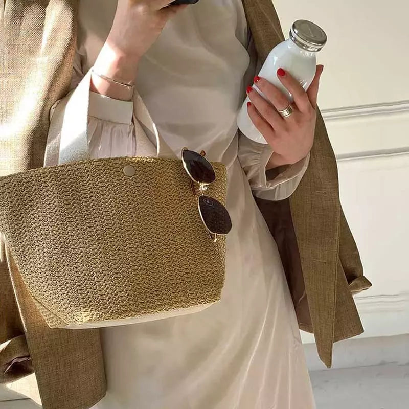 Mulher com bolsa de palha bege, óculos escuros, look minimalista verão, estilo casual chic