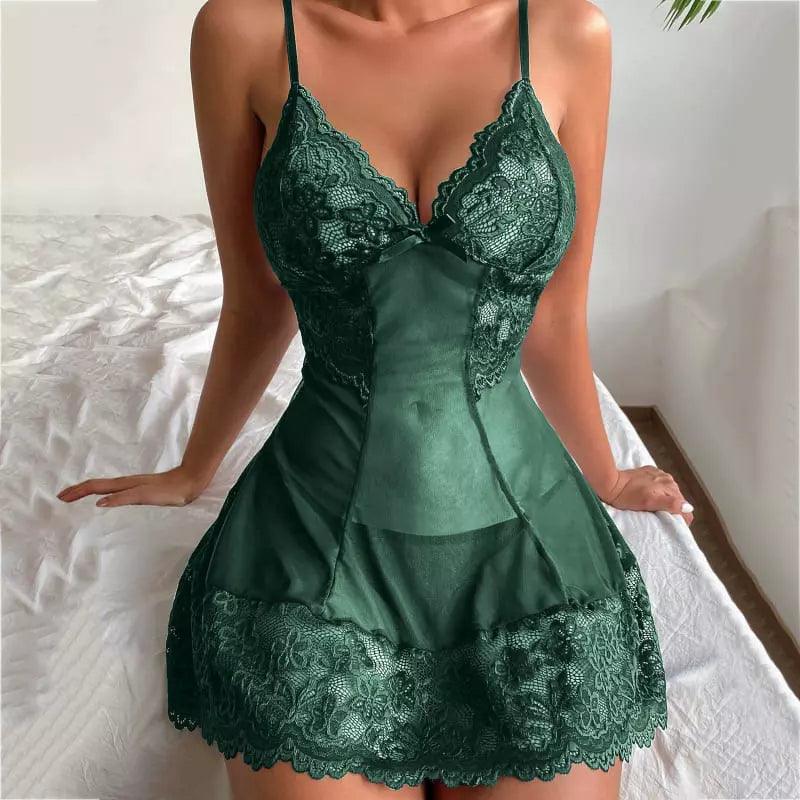 Mulher usando camisola rendada verde escura, com detalhes em renda sentada na cama.