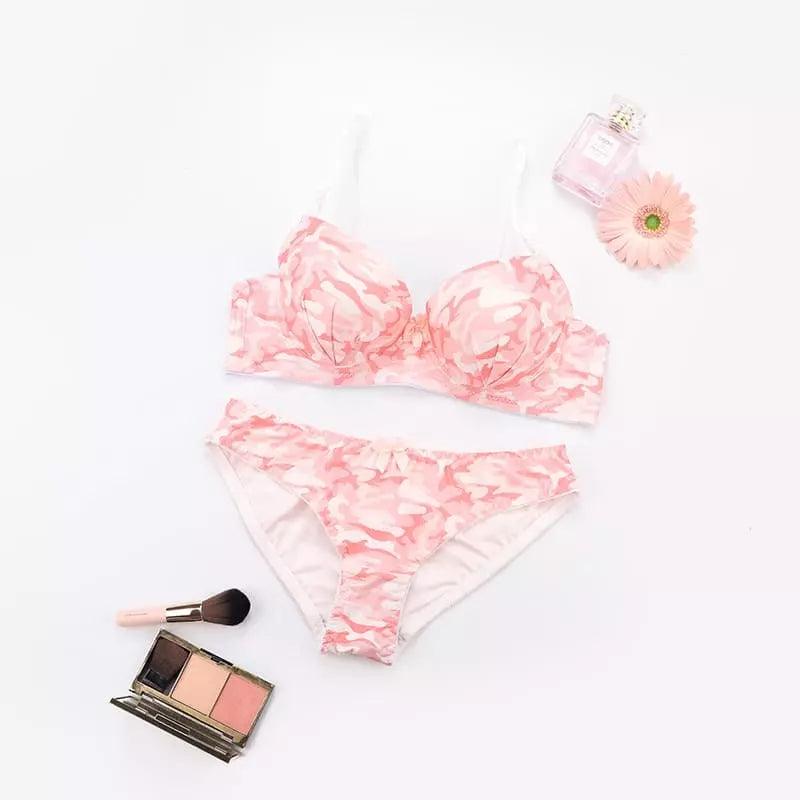 Conjunto lingerie rosa e branco com estampa delicada, perfume, flor e paleta de maquiagem