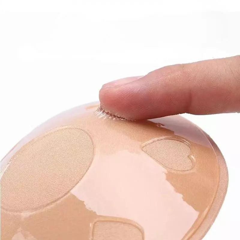 Sutiã adesivo nude em silicone, detalhe do toque no lado aderente mostrando a textura dos corações.