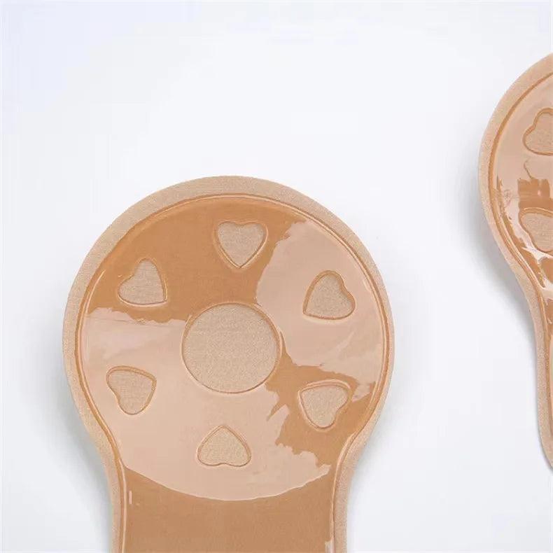 Sutiã adesivo nude com detalhes em alto relevo de corações, close na textura do silicone.