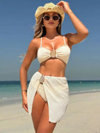 Biquíni branco com textura canelada, top com broche dourado e saída de praia pareô combinando