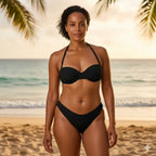 Mulher de biquíni preto na praia ao pôr do sol com coqueiros ao fundo