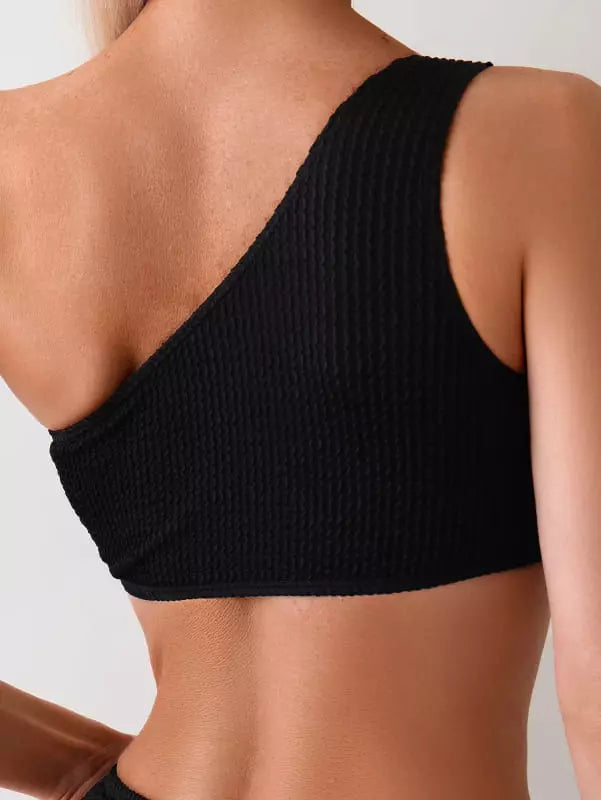 Detalhe costas de top biquíni preto canelado com alças cruzadas e textura nervurada moderna.