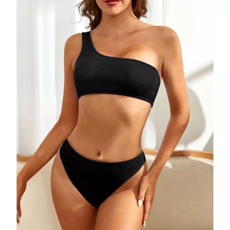 Biquíni preto canelado com top ombro único e calcinha cintura alta, modelo feminino elegante.