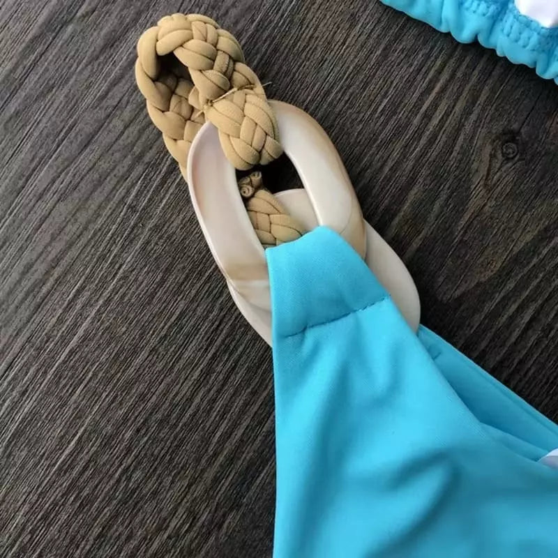 Detalhe biquíni azul turquesa com alça trançada bege e fivela branca decorativa