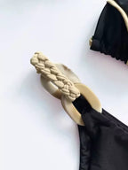 Detalhe calcinha biquíni preto com lateral trançada bege e argola decorativa