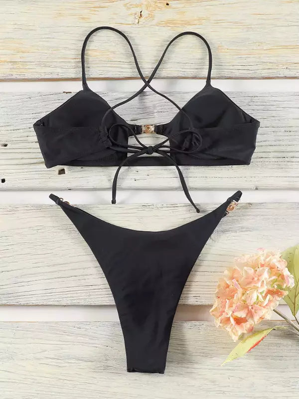 Biquíni preto com top de alças cruzadas e detalhe dourado, calcinha fio dental