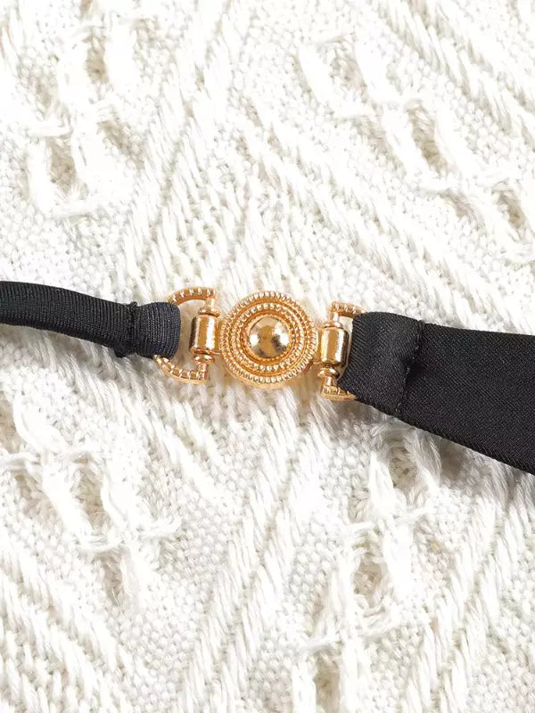 Fivela dourada circular decorativa com detalhes em relevo para biquíni preto