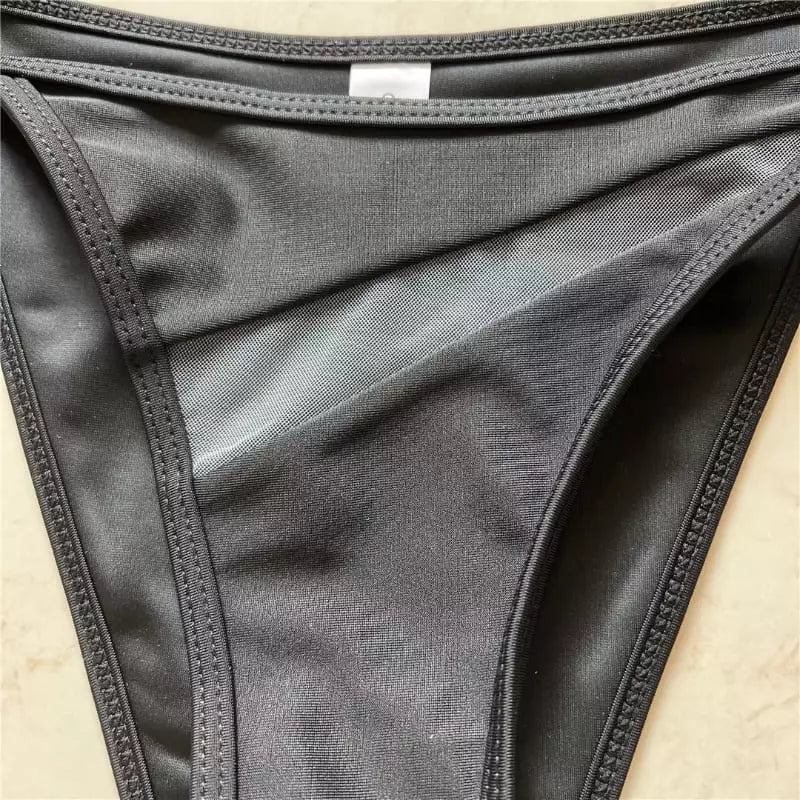 Detalhe da parte de baixo do biquíni feminino preto com recortes laterais