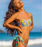 Biquíni tie dye com top um ombro só em azul e amarelo, calcinha com amarração lateral colorida.