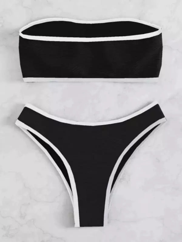 Conjunto de biquíni preto com textura ondulada, viés preto e estilo fio dental, fotografado em fundo de mármore branco