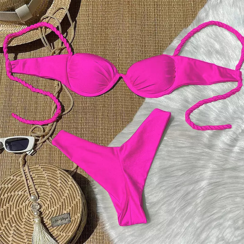 Biquíni rosa pink com bolsa de palha e óculos de sol sobre canga branca