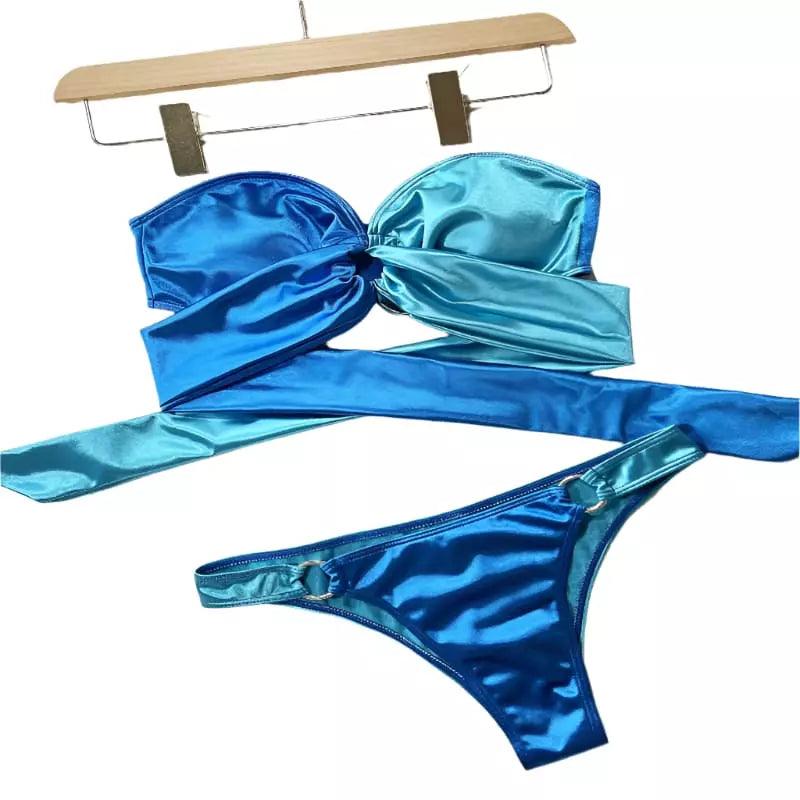 Biquíni metalizado azul degradê com top tomara-que-caia e tiras amarração, calcinha com argola lateral brilhante.