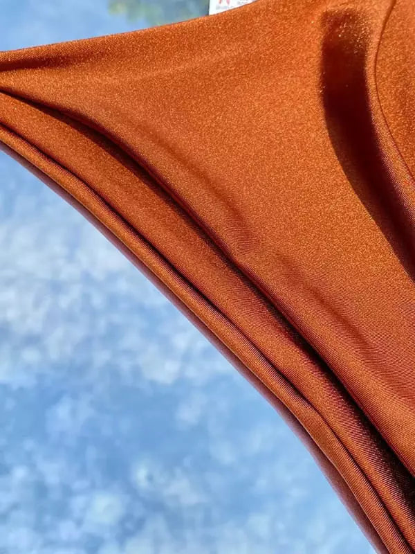 Calcinha de biquíni laranja com tecido drapeado e brilho metálico