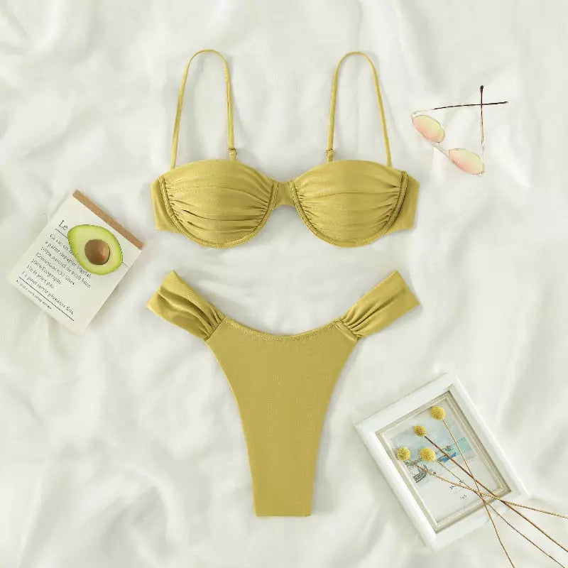 Biquíni amarelo dourado com top estruturado e calcinha cavada, flatlay moda praia com acessórios