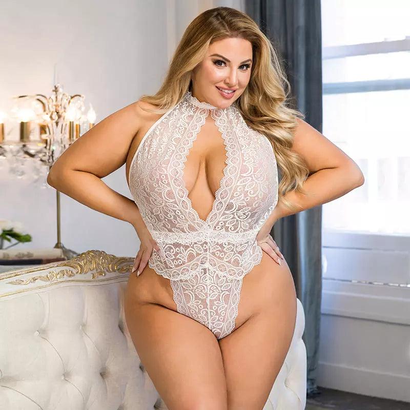 Body branco de renda plus size com gola alta e decote profundo em ambiente elegante com lustre.