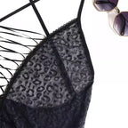 Detalhe de body preto com renda texturizada, alças cruzadas e óculos de sol ao fundo