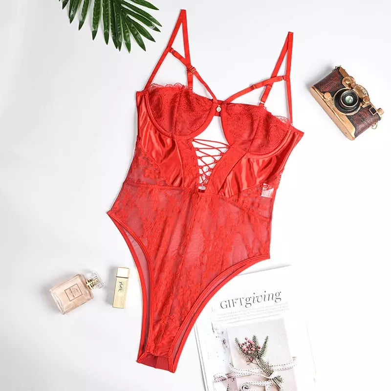 Body vermelho transparente com bojo e amarração em flatlay com câmera, perfume e folha de palmeira
