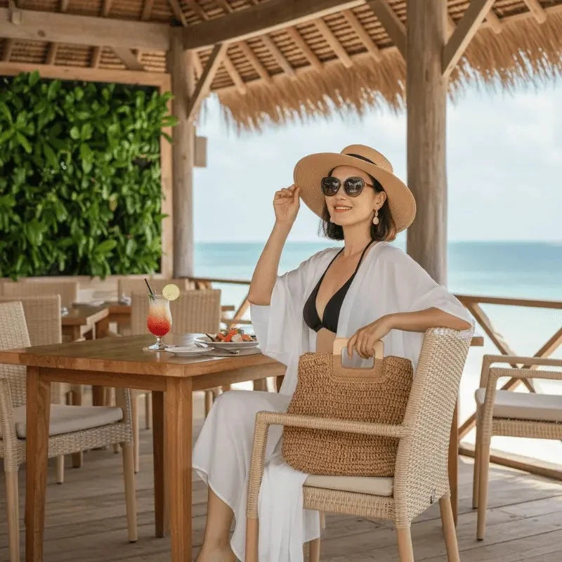 Mulher com biquíni preto, kimono branco e chapéu em resort tropical - moda praia