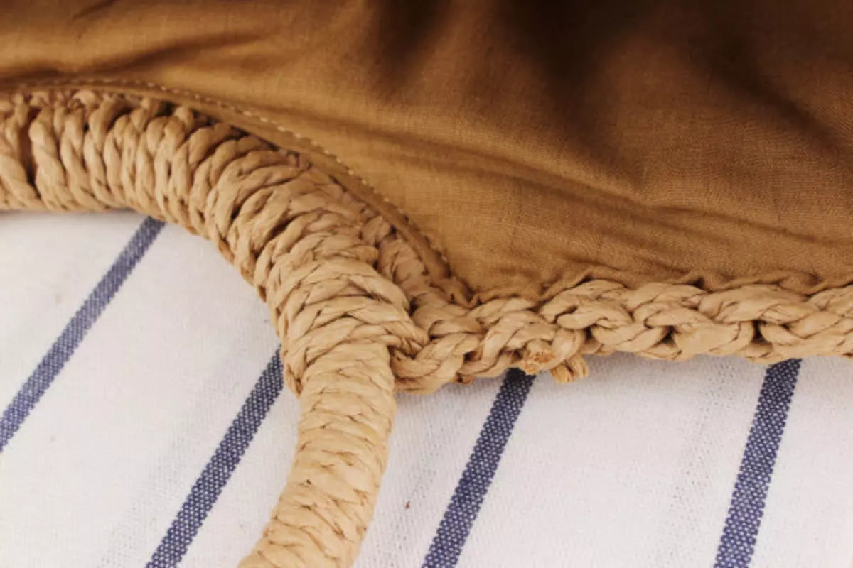 Bolsa de palha artesanal com alças trançadas e detalhes em tecido listrado azul e branco