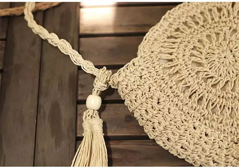 Bolsa redonda de crochê bege com alça trançada e pompom - acessório praia verão
