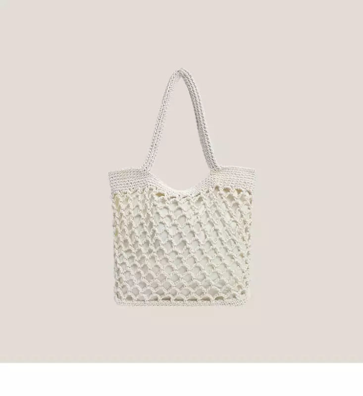 Bolsa de crochê branca com trama vazada e alças de ombro para look minimalista e elegante

