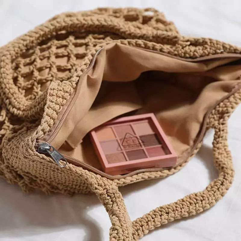 Interior de bolsa de crochê bege com forro bege e compartimento com zíper para organização