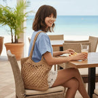  Mulher com camiseta azul e bolsa de crochê bege em restaurante à beira-mar para look casual verão