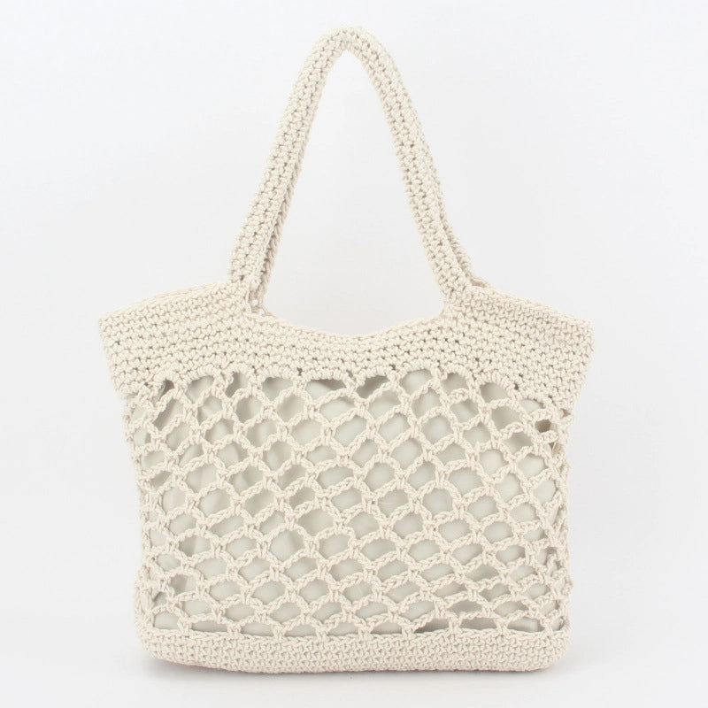 Detalhes de bolsa de praia crochê branca com trama vazada, zíper e forro interno.