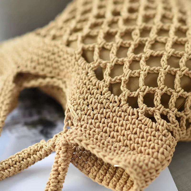 Detalhes de bolsa de praia crochê bege com trama vazada, alças reforçadas e forro interno.