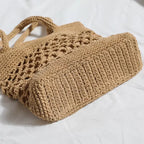 Detalhes de bolsa de praia crochê branca com trama vazada, alças reforçadas e forro com zíper.