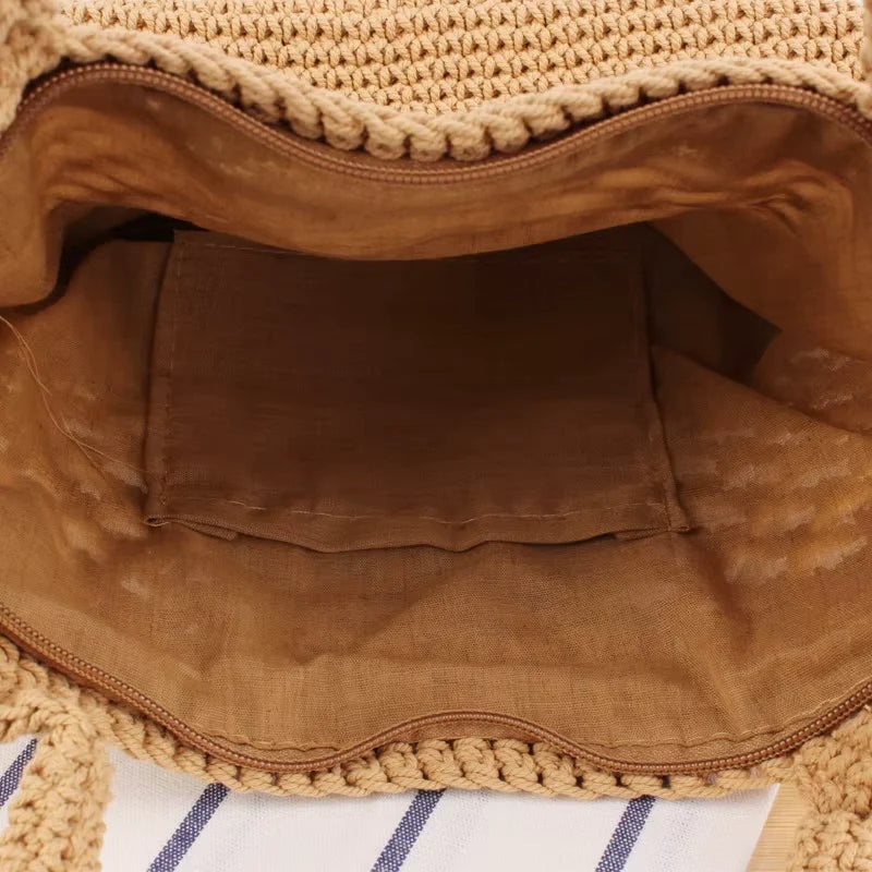 Detalhes de bolsa de praia crochê branca com trama vazada, alça reforçada e forro com zíper.