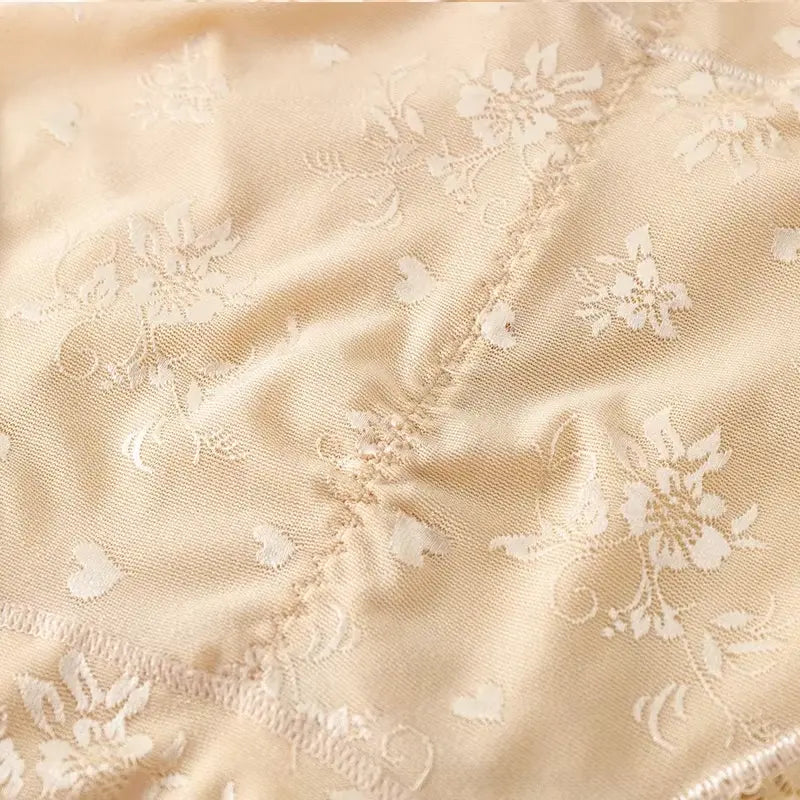 Detalhe do tecido com renda floral delicada da calcinha modeladora cintura alta bege