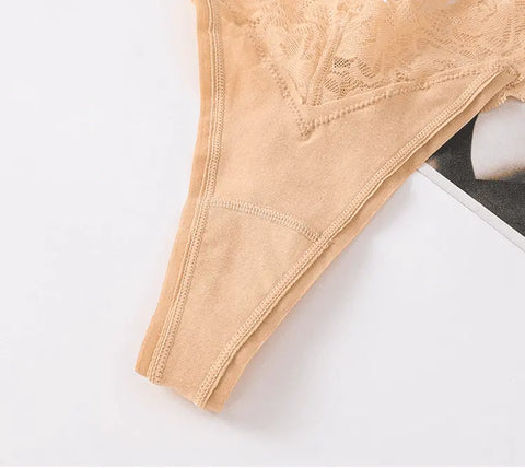 A imagem mostra uma visão de perto de uma peça de lingerie de renda bege. A renda tem um padrão intrincado e delicado.