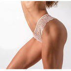 Calcinha brasileira nude em renda delicada, modelo lateral fina com acabamento floral e laço. Visual elegante e sensual.