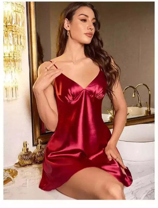 Camisola vermelho rubi em cetim brilhante com alças finas e decote V, em ambiente luxuoso com detalhes dourados.