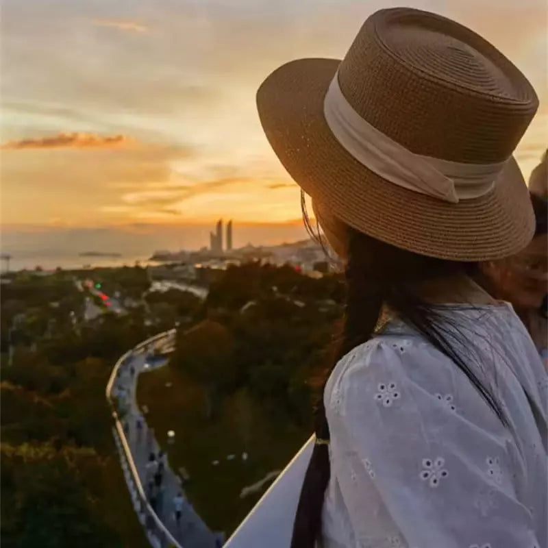 Chapéu de palha marrom com faixa branca ao pôr do sol look casual feminino