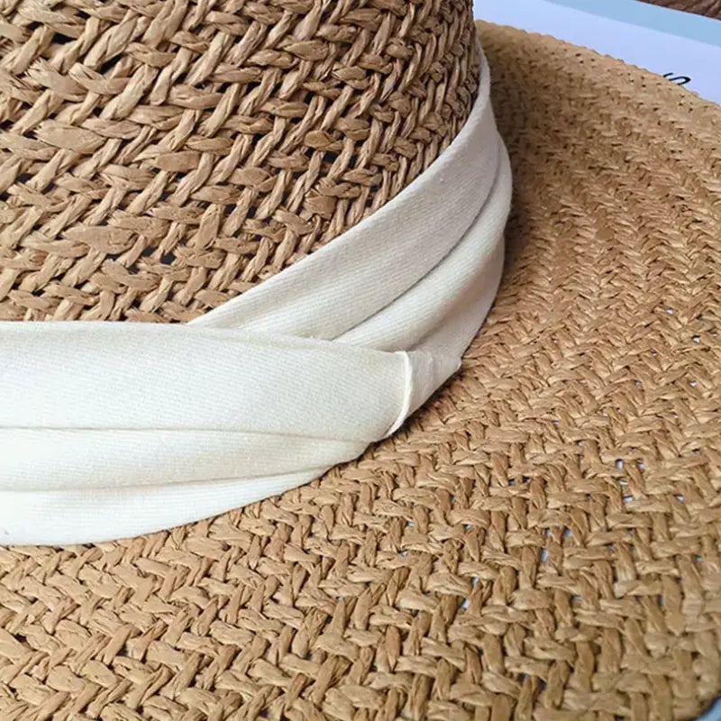 Chapéu de palha com textura trançada natural e faixa branca elegante, detalhe artesanal