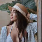 Chapéu de palha bege com faixa branca, camisa listrada azul e colar cruz dourado verão