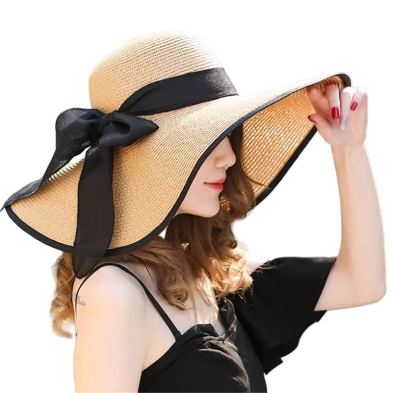 Uma mulher usando um elegante chapéu de palha bege com fita preta, perfeito para proteção solar
