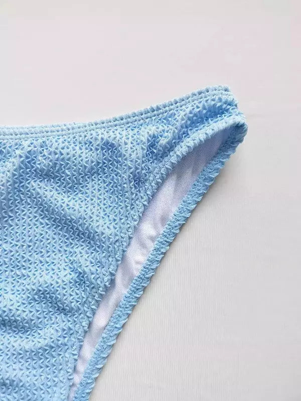 Calcinha biquíni azul bebê com textura rendada e acabamento desfiado moda praia feminina