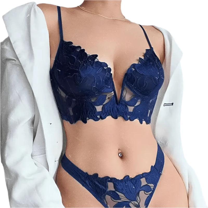 Conjunto lingerie azul marinho com renda floral e detalhes vazados, usando blazer branco por cima
