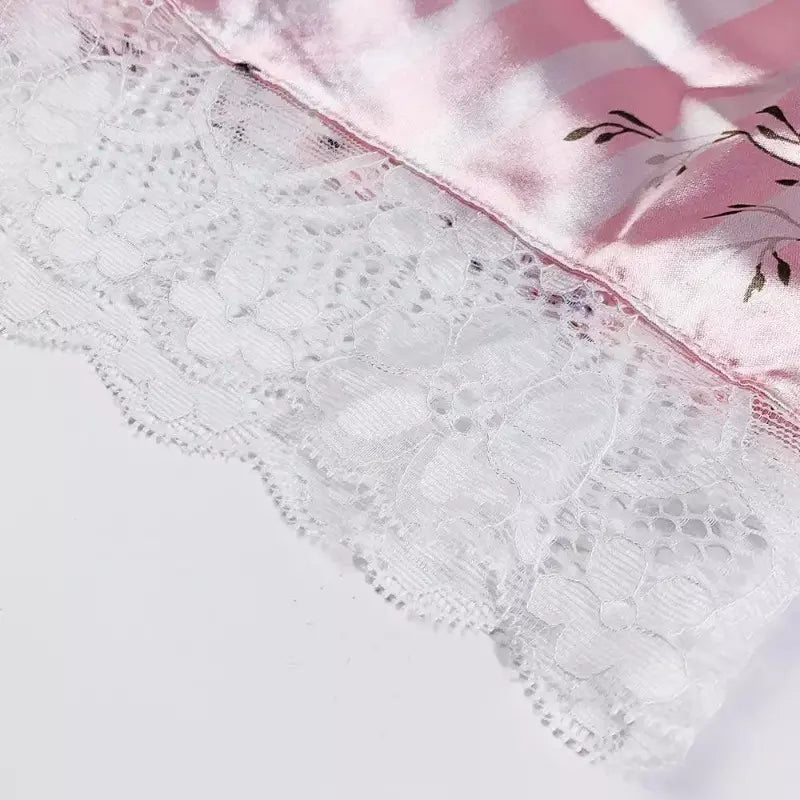 Detalhe de lingerie delicada com renda floral branca e tecido acetinado rosa, acabamento refinado para peças íntimas femininas.