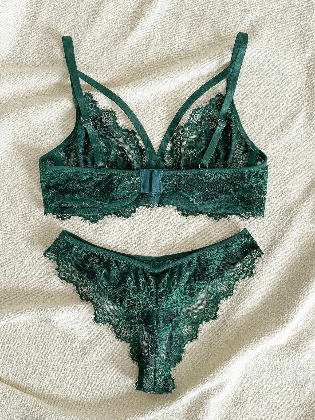 Imagem de um conjunto de lingerie verde escuro com detalhes em renda.