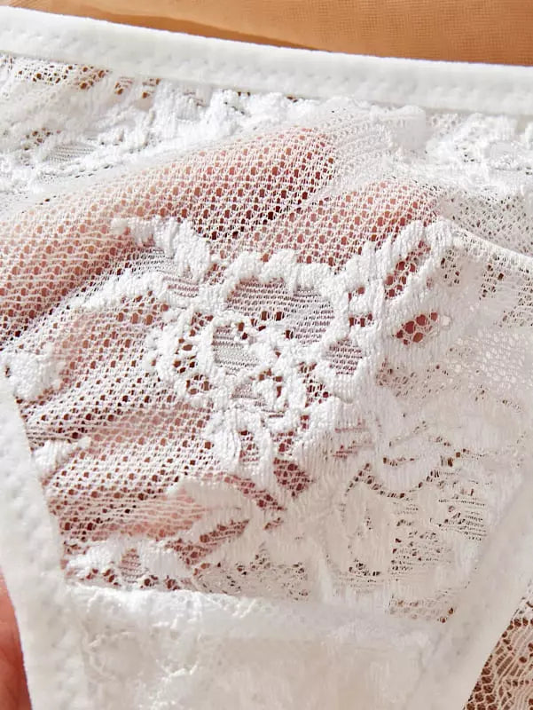 Tecido branco com renda floral delicada e detalhes vazados