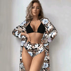 Biquíni tropical com saída de praia coordenada, top preto e calcinha estampada floral em tons de azul e branco